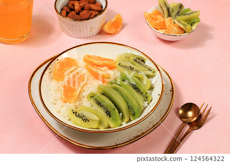 Rice pudding with kiwi, honey, tangerines and almonds. Healthy breakfast with ingredients, flat lay, Healthy and natural food concept, lifestyle, food for children, 124564322