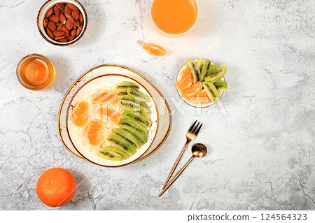 Healthy breakfast with ingredients, Rice pudding with kiwi, honey, tangerines and almonds.flat lay, Healthy and natural food concept, lifestyle, food for children, 124564323