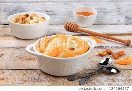 Rice pudding with bananas, honey, tangerines and almonds. Healthy breakfast with ingredients, flat lay, Healthy and natural food concept, lifestyle, food for children 124564327