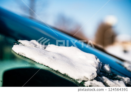 ice and snow on the front windshield of a vehicle. 124564391