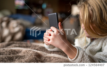Young girl using an e-reader tablet to enjoy a book. 124564407
