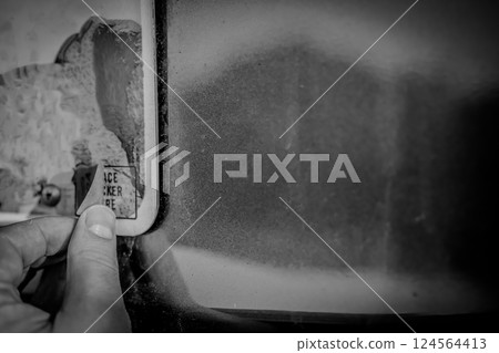 Affixing a new license registration sticker on a vehicle plate. Affixing a new license registration sticker on a vehicle plate. 124564413