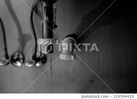 selective focus on a bathroom sink drain disconnected with a hair clog hanging down selective focus on a bathroom sink drain disconnected with a hair clog hanging down 124564418