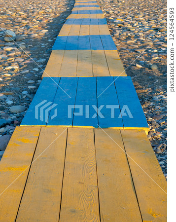 Yellow-blue flooring. Boardwalk to the beach. 124564593