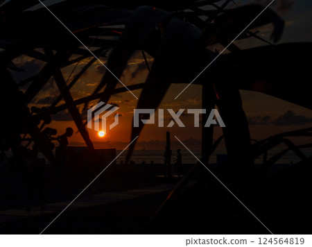 Sunset over the sea in a resort place. Evening on the beach. Beautiful orange sunset. Evening in Baumi. Black Sea coast. Rest on the sea. 124564819