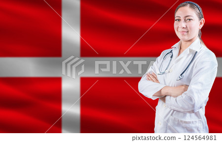 Female doctor on danish flag. Doctor with crossed arms on danish flag. Denmark health and care concept 124564981