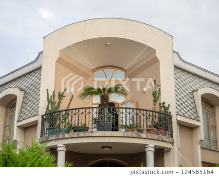 Facade of an expensive house with palm trees. Housing with a balcony. Beautiful house. The concept of good housing. 124565164