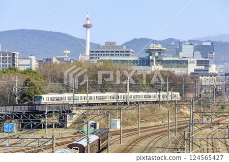 JR Sagano Line train running with Kyoto Tower in the background JR Sagano Line train running with Kyoto Tower in the background 124565427