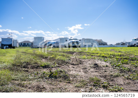Selective focus on mud and torn up grass in the foreground of a dirt parking lot Selective focus on mud and torn up grass in the foreground of a dirt parking lot 124565719