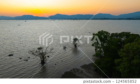 Aerial view of the golden sun slow down behind the mountain Aerial view of the golden sun slow down behind the mountain 124565852