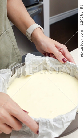 Female hand holding a cake pan with a delicious homemade cheesecake 124566499