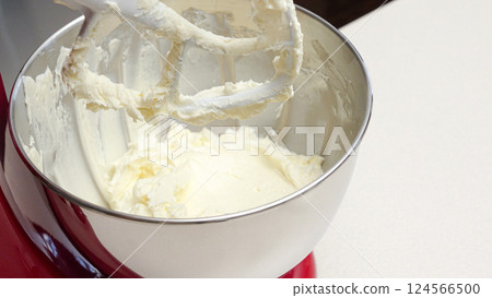 Vibrant Red Stand Mixer with Stainless Steel Bowl Mixing Yellow Batter Vibrant Red Stand Mixer with Stainless Steel Bowl Mixing Yellow Batter 124566500