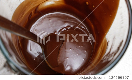 Close-up of a chocolate fudge in a glass measuring cup with a spoon Close-up of a chocolate fudge in a glass measuring cup with a spoon 124566507