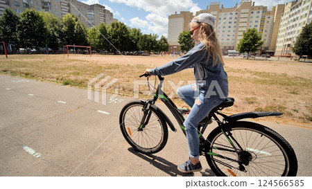 Young student enjoying cycling in a city park, promoting healthy lifestyle and outdoor activities for children Young student enjoying cycling in a city park, promoting healthy lifestyle and outdoor activities for children 124566585