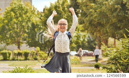 Happy eleven year old schoolgirl jumps in happy emotions. 124566599