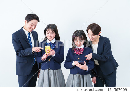 Girl using smartphone, parents watching Girl using smartphone, parents watching 124567009