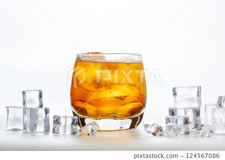 Sparkling drink. A glass of apple spritzer or Apfelschorle on a white background. Cold carbonated apple juice. Homemade spritzer served with ice. Sparkling drink. A glass of apple spritzer or Apfelschorle on a white background. Cold carbonated apple juice. Homemade spritzer served with ice. 124567086