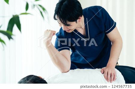 A male chiropractor performing a treatment 124567735