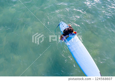 Drone view of Asian Surf board man plays surf in the sea beach at Kata Beach, Phuket Thailand. Drone view of Asian Surf board man plays surf in the sea beach at Kata Beach, Phuket Thailand. 124568607