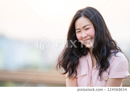Close up to Young Asian Girl face, she is smiling and happy on rooftop at sunset time, twilight time. Close up to Young Asian Girl face, she is smiling and happy on rooftop at sunset time, twilight time. 124568634