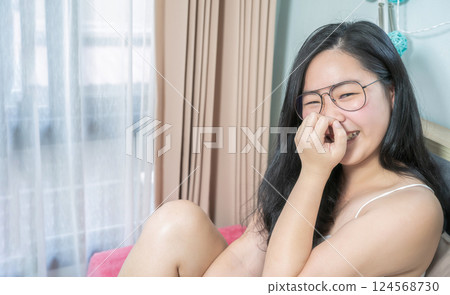 Asian Glasses Woman relax on her bed in the morning at her bedroom. Asian Glasses Woman relax on her bed in the morning at her bedroom. 124568730