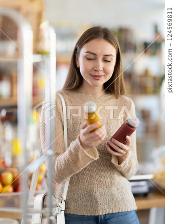 Portrait of young girl choosing smoothie products in supermarket Portrait of young girl choosing smoothie products in supermarket 124569811