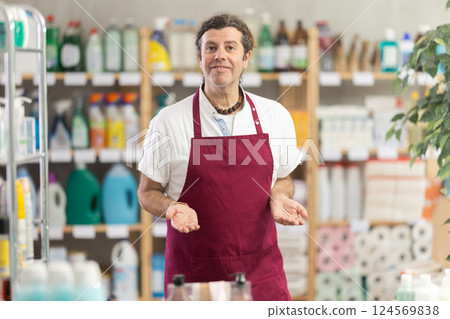 Man seller in apron invite and working in households store Man seller in apron invite and working in households store 124569838