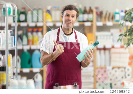Adult male seller offering cleaning spray Adult male seller offering cleaning spray 124569842