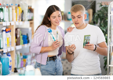 Couple man and woman choosing toothbrush in store 124569865
