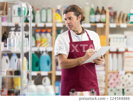 Adult man seller conducting inventory in store Adult man seller conducting inventory in store 124569866