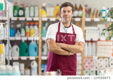 Man seller in apron invite and working in households store Man seller in apron invite and working in households store 124569873