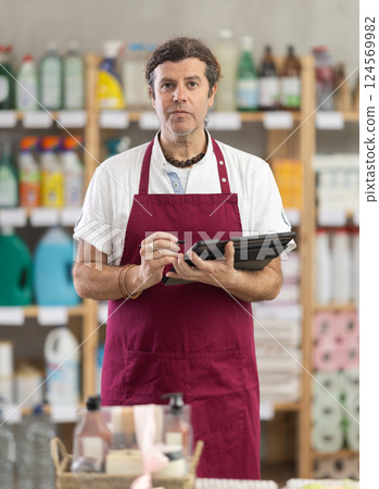 Adult man seller conducting inventory with tablet Adult man seller conducting inventory with tablet 124569982