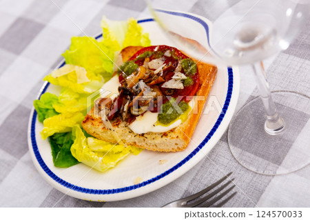Hot sandwich with baked tomatoes, mushrooms, chorizo and cheese 124570033