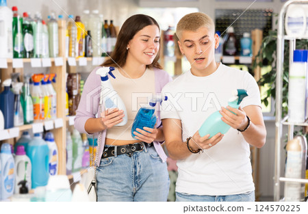 Couple man and woman choosing cleaning spray in store 124570225
