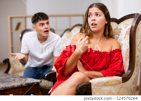 Disgruntled young husband swears at his wife 124570264