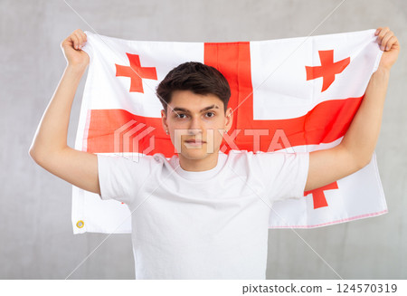 Focused young guy holding Georgia flag 124570319