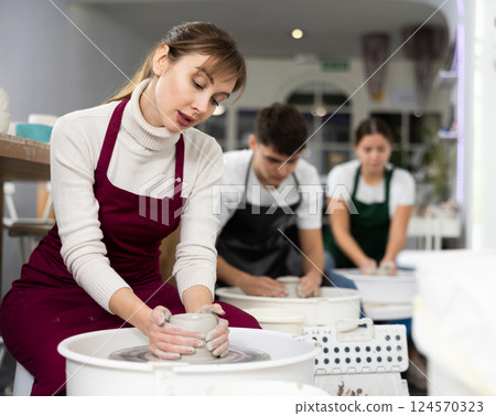 Young woman sculpting product on potter's wheel 124570323