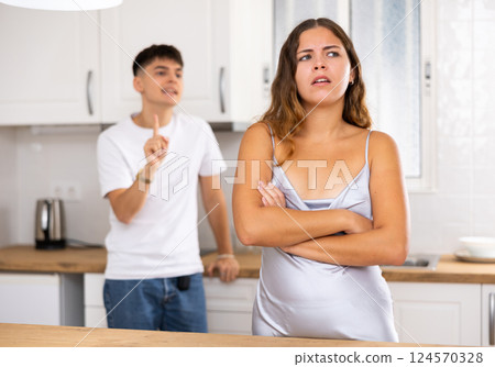 Usual domestic quarrel of young family in kitchen Usual domestic quarrel of young family in kitchen 124570328