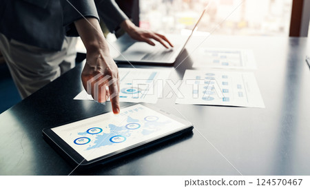 Female business person using laptop and tablet PC in urban office building 124570467