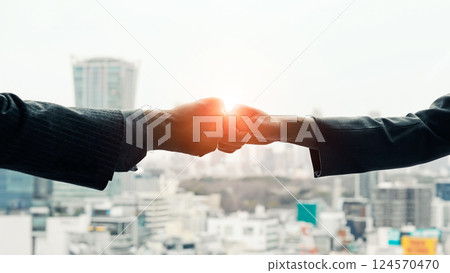 一群商界人士在城市背景下碰拳 一群商界人士在城市背景下碰拳 124570470