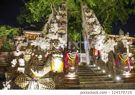Night view of Pura Dalam Ubud with its cracked gates and statues in Bali Night view of Pura Dalam Ubud with its cracked gates and statues in Bali 124570729