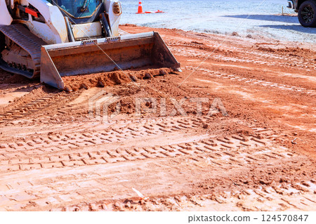 Heavy machinery is leveling ground at construction site for foundation 124570847