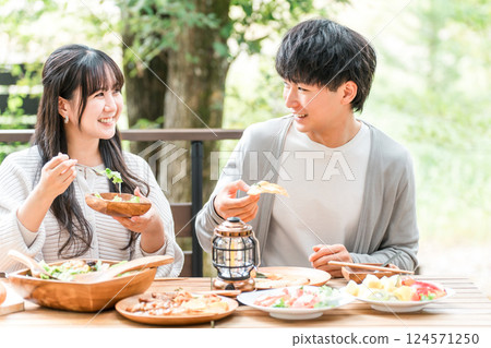 Couples and married couples dining on a wooden deck, terrace, or balcony (glamping/verandaping) 124571250