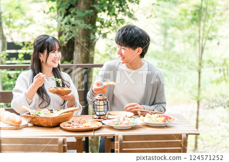 Couples and married couples dining on a wooden deck, terrace, or balcony (glamping/verandaping) 124571252