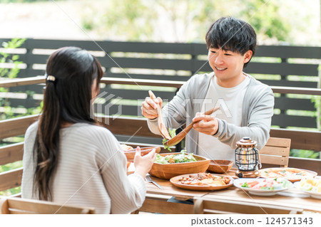 Couples and married couples dining on a wooden deck, terrace, or balcony (glamping/verandaping) 124571343