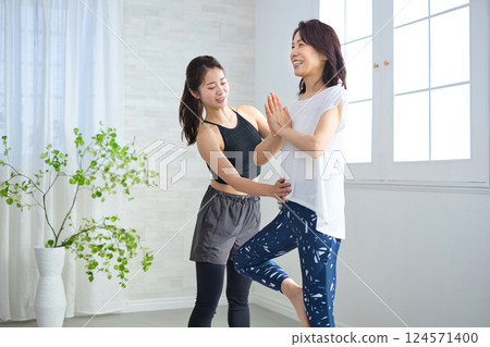 Middle-aged woman receiving lessons from a yoga instructor 124571400
