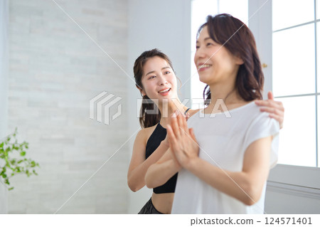 Middle-aged woman receiving lessons from a yoga instructor 124571401