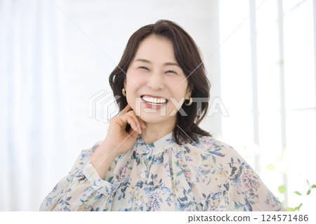 一位身穿花襯衫、微笑的中年婦女 124571486