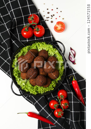 Falafel in a plate, on a light background. Falafel in a plate, on a light background. 124571558