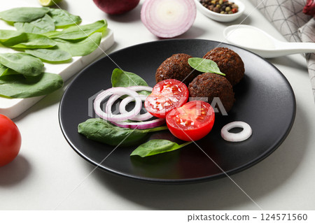 Falafel in a plate, on a light background. 124571560
